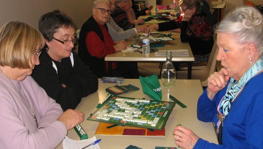 Joueuses de Scrabble réunies autour de plusieurs tables